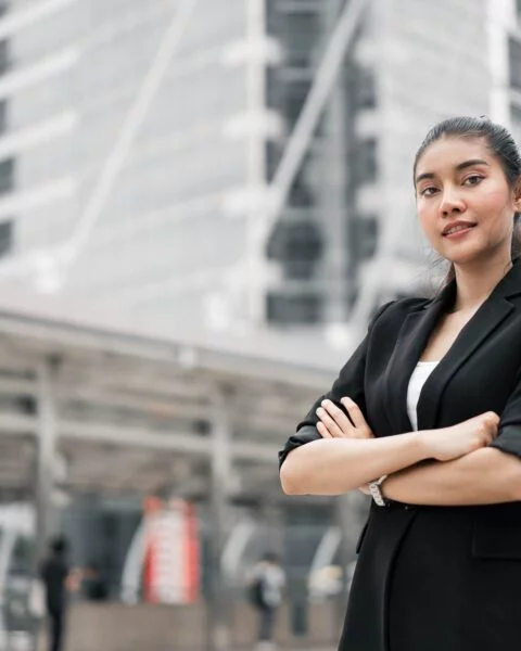 portrait-young-businesswoman-with-arms-crossed-standing-footpath